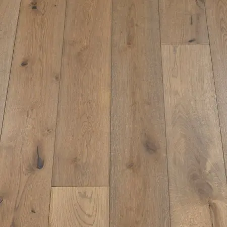 A close-up view of natural ash wood flooring, showcasing the smooth grain texture and light brown colour tones. The planks have a uniform appearance with subtle variations in shading, highlighting the natural beauty of the ash wood.