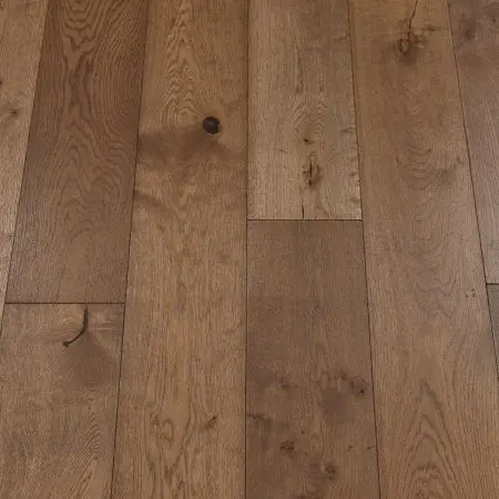 A close-up of coffee-colored wood plank flooring, exhibiting rich, dark brown hues with a smooth, matte finish. The natural wood grain is visible, giving the floor a warm and inviting appearance.