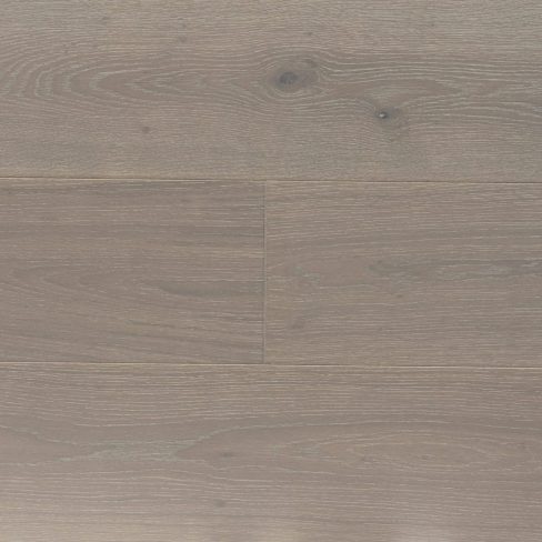 A top-down view of Universal Clic Misted Oak laminate flooring swatch, displaying soft, neutral beige tones with a slightly weathered appearance. The realistic wood grain and delicate texture provide a natural, understated aesthetic.